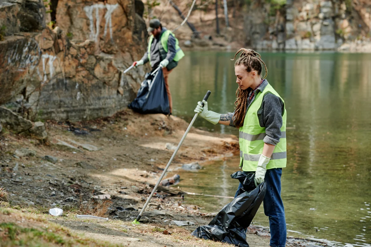 Individuals participating in community service by cleaning up a natural area, wearing safety vests and gloves, reflecting the structured obligations of Texas DUI sentencing.